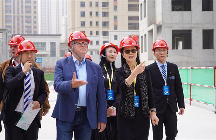 中翔集团董事长孙维芳(右二)向嘉宾介绍被动房建设情况